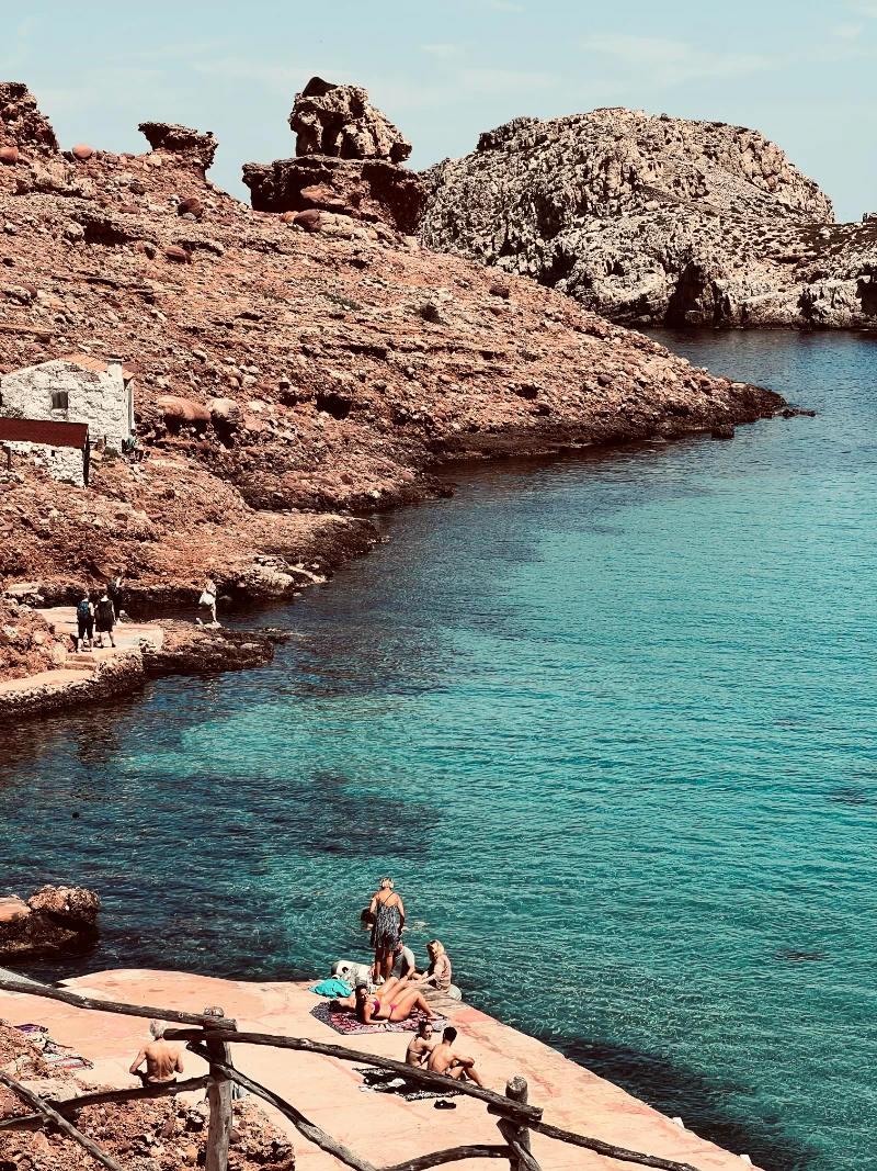Agua cristalina en una plataforma de baño en Cala Morell, Menorca.